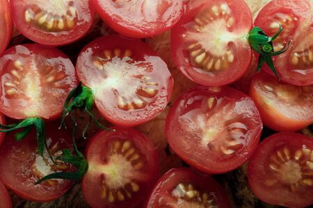 Fresh season's cherry tomato halves sliced on the wooden tableの写真素材