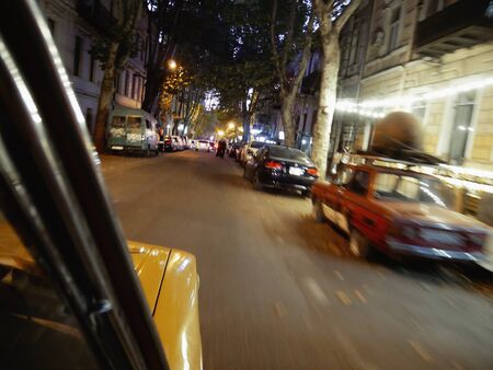 Driving around Tibilisi in Georgia in old russian lada car at night seen from the passenger perspectiveの写真素材