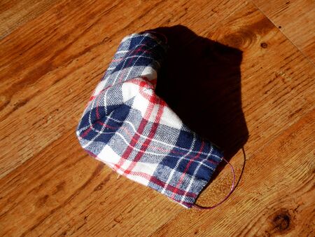 Checkered self made face mask on wooden surface