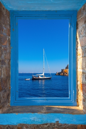 View of a sailing boat threw a window  in Santorini island Greeceの写真素材