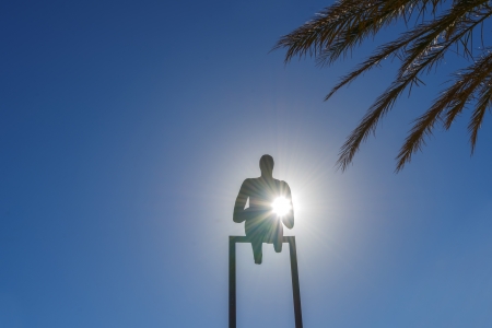 Statue of a man raising his hand with sun backgroundのeditorial素材