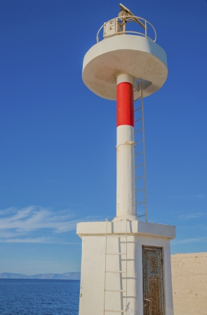 Traditional lighthouse closeup view in Syros island in Greece by main harborの写真素材