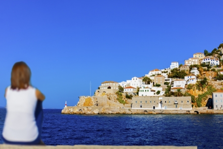 Woman looking at main port of Greek island Hydra at Saronikos Gulfの写真素材