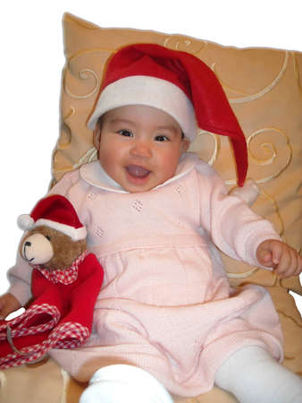 A Baby girl and a Teddybear with Santa hats isolatedの写真素材