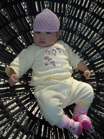 A Baby girl lies in a childrens swingの写真素材