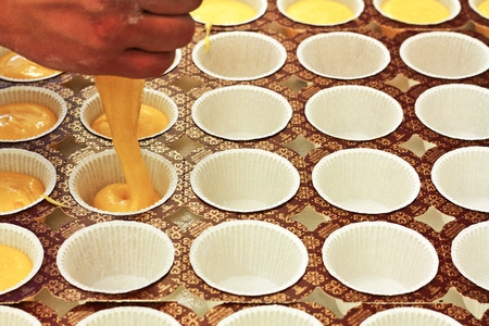 decorating and piping buttercream icing on  cupcakes
