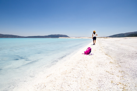 Woman tourist walking on tropical summer vacation wearing sun hatの写真素材