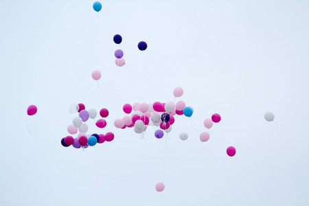 Balloons over a clear white sky.の写真素材