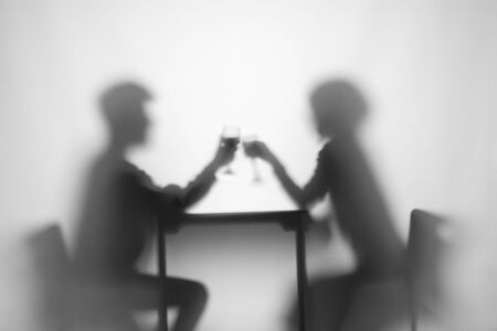 Relationship. Girl, boy at table with wine glassの写真素材