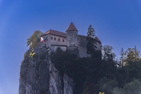 Medieval Bled Castle (Blejski grad), XI century, and the Lake Bled. Bled town, Gorenjska, Triglav National Park, Slovenia, central Europe. On background, the peaks of Triglav or Tricorno and Rjavina.の写真素材