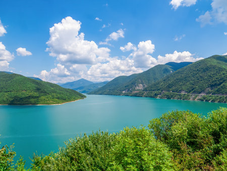 Panorama of Zhinvali Reservoir with turquoise water, surrounded by picturesque Caucasus Mountains on...
