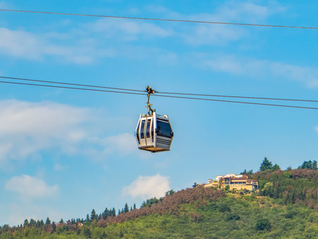 Modern cable cars moving above Tbilisi, Georgia, with a scenic panoramic view of the city. A unique urban transport system and a popular tourist attraction offering breathtaking aerial perspectives.の写真素材
