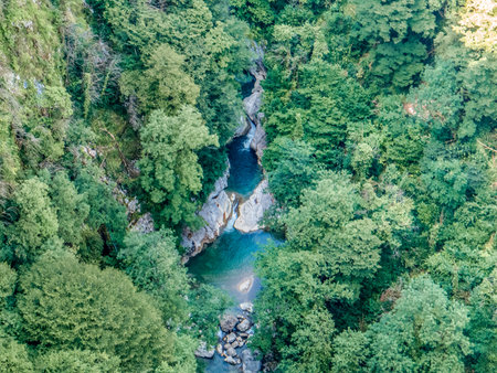 Aerial view of the canyon in Georgia, with the river winding through the dramatic cliffs and lush greenery, showing the breathtaking natural landscape.の写真素材