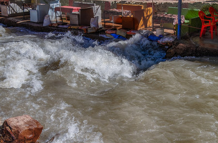 Ourika valley mountain river with rocks at front and hills at backの写真素材