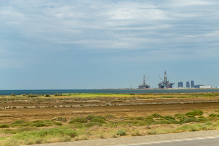 Baku, Azerbaijan. Beach waves with oil platform in ocean. Caspian sea offshore oil rig drilling platform off the Baku, Azerbaijan.の写真素材