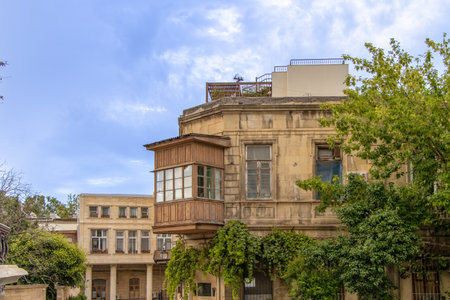 Baku, Azerbaijan. View of a traditional wooden balcony of a house in the center of the old city. The use of both open, ornate iron balconies and enclosed wooden or stone balconies is a typical feature of Baku's historical buildings.の写真素材