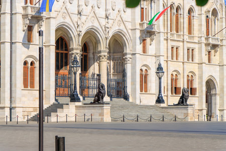 Budapest, Hungary. A stunning historical building with intricate architectural details, featuring a prominent lion statue and arched windows. Hungarian Parliament Building.の写真素材