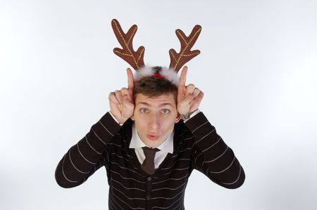 Young man wearing deer's horns depicts mooing and horning. High angle view. Isolated.の写真素材
