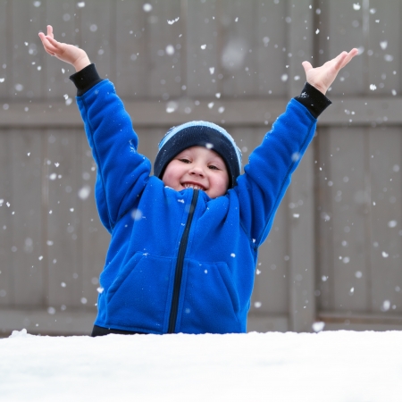happy boy catching snowflakesの写真素材