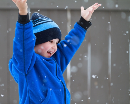 happy boy catching snowflakesの写真素材