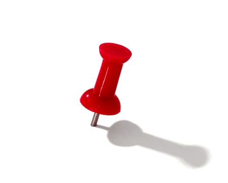 red thumbtack over white background 
