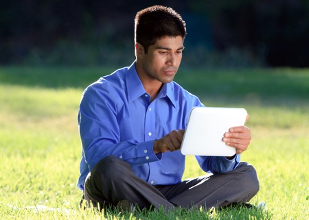 young businessman at the park working with tablet の写真素材