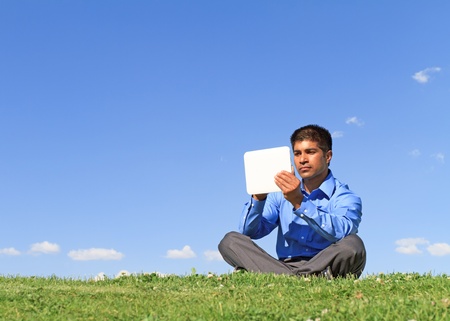 young businessman at the park working with tablet の写真素材