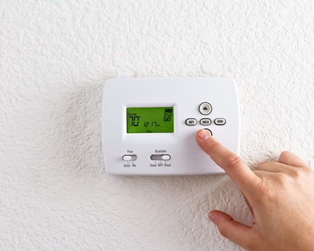 digital thermostat with finger pressing button の写真素材