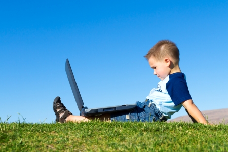 little boy with laptop outdoorsの写真素材