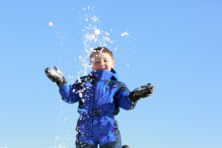 boy throwing snowの写真素材