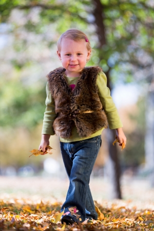 cute little girl with fall leavesの写真素材