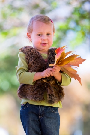 cute little girl with fall leavesの写真素材