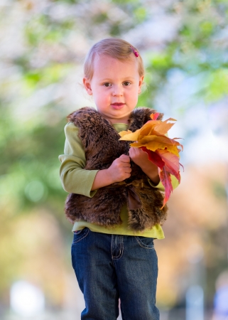 cute little girl with fall leavesの写真素材