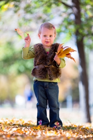 cute little girl with fall leavesの写真素材