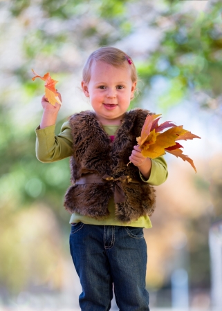 cute little girl with fall leavesの写真素材