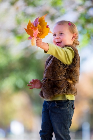 cute little girl with fall leavesの写真素材