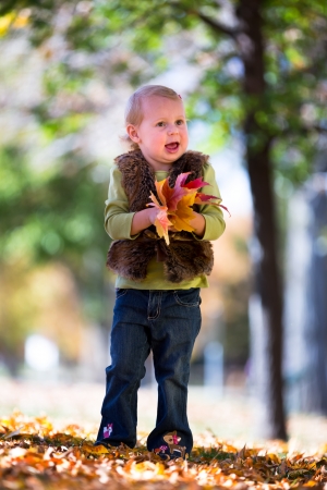 cute little girl with fall leavesの写真素材