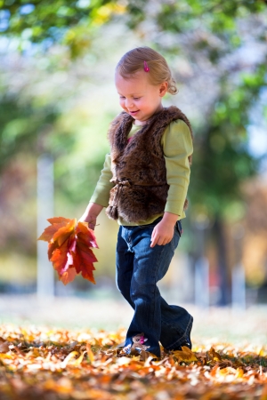 cute little girl with fall leavesの写真素材
