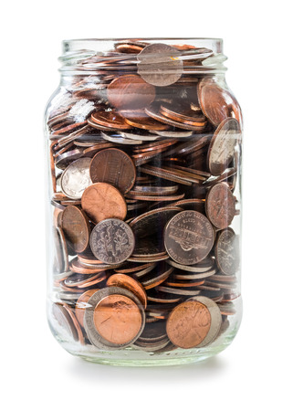 Jar full of coins isolated on whiteの写真素材
