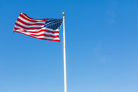 American flag against clear blue skyの写真素材
