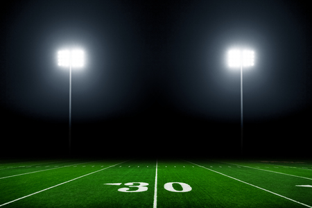 American football field at night with stadium lightsの写真素材