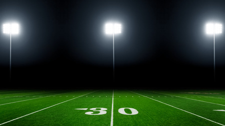 American football field at night with stadium lightsの写真素材