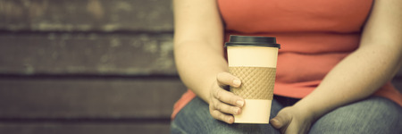 Woman sitting on the bench with cup of coffeeの写真素材