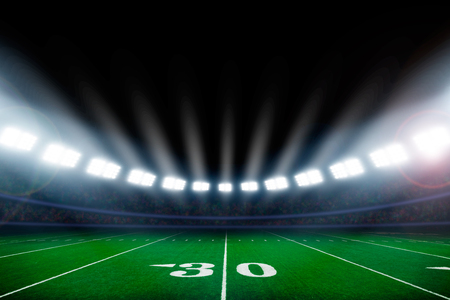 American football field illuminated by stadium lightsの写真素材