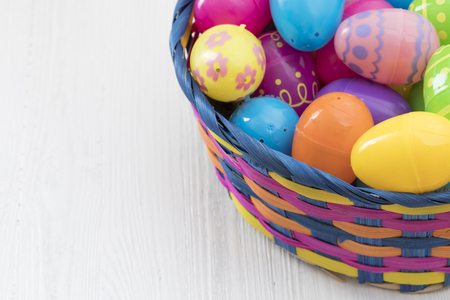 Easter eggs in basket on white wooden backgroundの写真素材