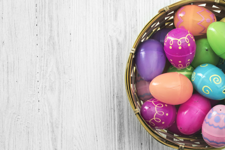 Easter eggs in basket on white wooden backgroundの写真素材