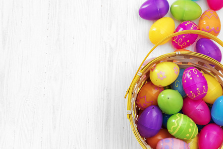 Easter eggs in basket on white wooden backgroundの写真素材