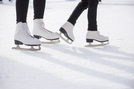 Young women ice skating on ice rinkの写真素材