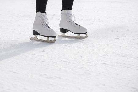 Young woman ice skating on ice rinkの写真素材