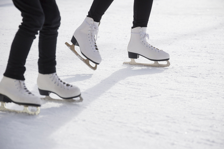 Young women ice skating on ice rinkの写真素材